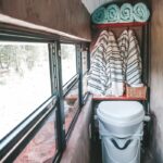 (14) The toilet closet, with storage shelves behind.