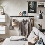 a-wall-with-cabinets-a-rack-hanging-clothes-and-art-canvases-11e9432c07c2a334ffea5962dafdeebd